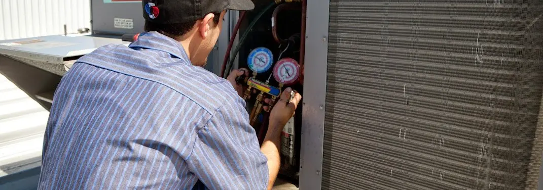 HVAC technician servicing a condenser unit in Fernandina Beach
