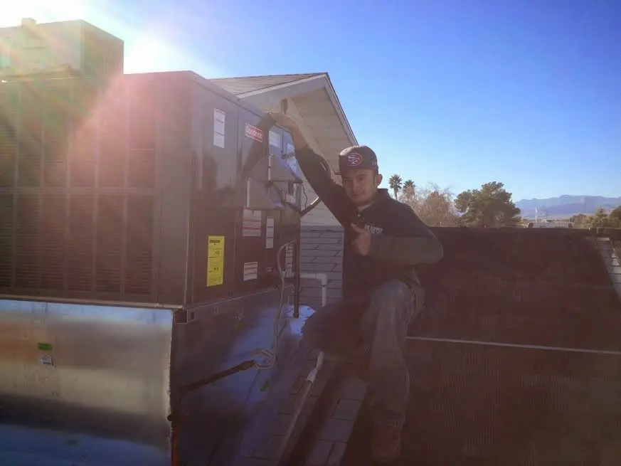 HVAC technician performing Heat Pump Repair on a rooftop unit in Fernandina Beach